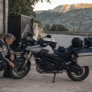 Motorista comprobando su moto antes de comenzar un Viaje autoguiado